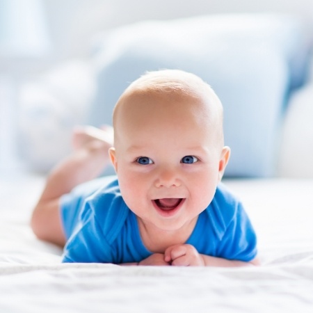 Smiling baby lying on some sheets