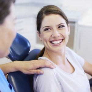 Woman in white shirt smiling at her dentist