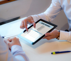 Someone in a white shirt holding an ipad with ‘Dental Insurance’ indicated