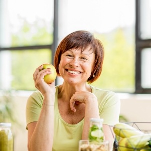 Woman sitting down and holding an apple