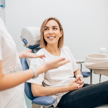 Woman in white shirt sitting and smiling