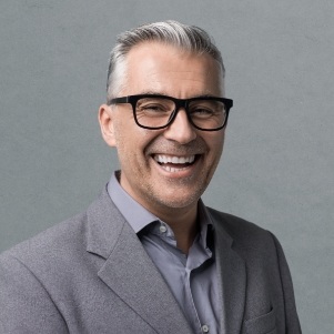 Man with suit and glasses smiling