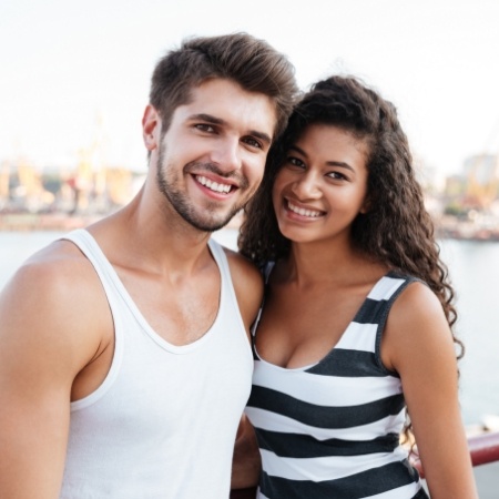 Man and woman smiling in front of lake
