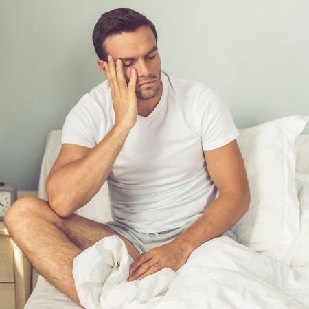 Man with sleep apnea awake in bed