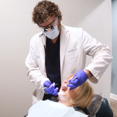 Dentist treating a patient in dental chair