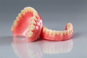 A pair of dentures sitting on a grey surface